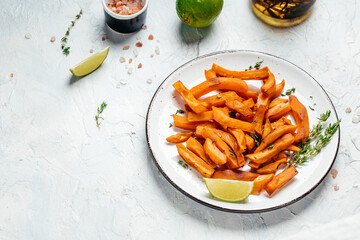 Homemade baked orange sweet potato with lime and herbs on plate on light background. banner, menu, recipe place for text, top view