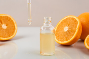 Pipette with orange essential oil over bottle and oranges. Natural medicine concept. Aromatherapy
