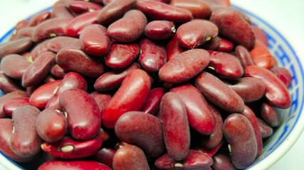 Detail view on kidney beans in the Chinese porcelain bowl on the white background.