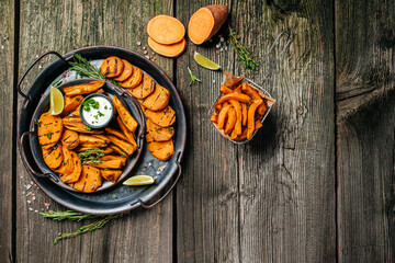 Sweet potatoes fries with lime and herbs yogurt sauce. banner, menu, recipe place for text, top view
