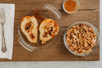 Baked pears with walnuts, honey, and cinnamon, close up o rustic background