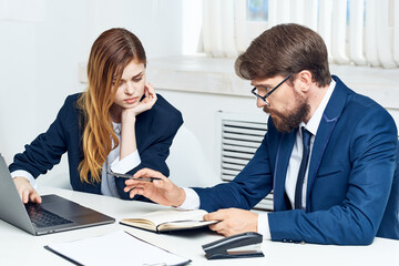 Fototapeta premium colleagues chatting in the office in front of a laptop officials