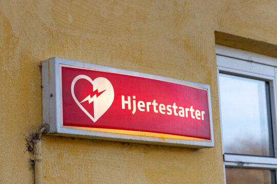 building with the illuminated danish word for defillibrator to provide first aid