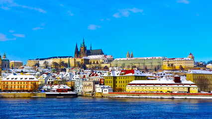 Fototapeta na wymiar Prague castle with New Town during freezing winter and beautiful blue sky. All the roofs are covered with snow.