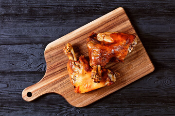 roasted pork shanks on a wooden board, top view