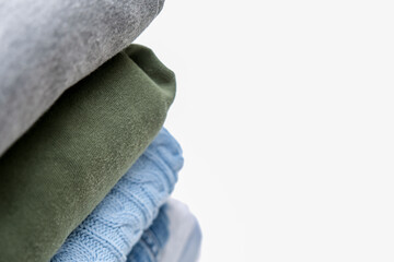 Folded stacked warm winter and autumn casual clothes close up with copy space