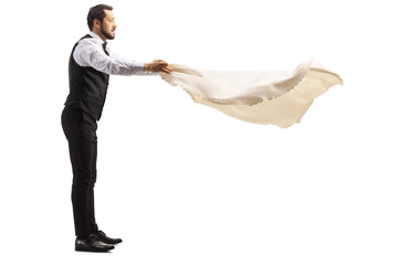 Full length profile shot of a server holding a tablecloth