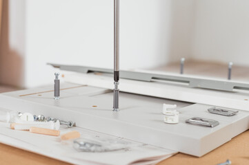 Carpenter services concept. Assembling kitchen furniture on the floor with screwdriver