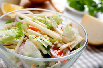 Delicious turnip salad with vegetables in glass bowl, closeup