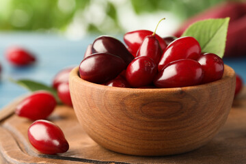 Fresh ripe dogwood berries in wooden bowl on board, closeup