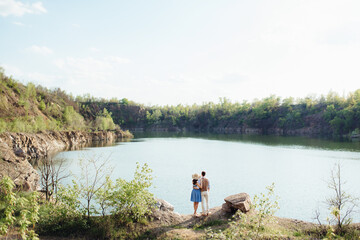 a young couple a guy and a girl are walking near a mountain lake surrounded