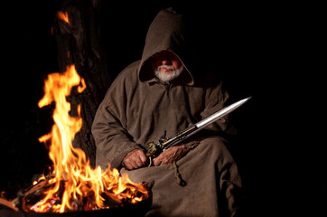 Warrior in the Middle Ages with sword by the fire
