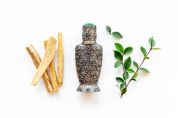 Agar wood tree oil perfume in silver bottle with sticks of tree