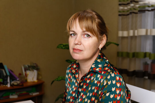 Portrait Of Elegant Mature Woman Wearing Blouse And Looking At Camera. Closeup Of Confident Woman Sitting At Home Office. Successful Lady Indoor. Blonde Lady