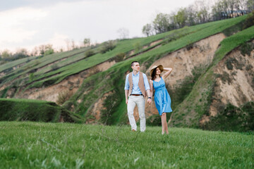 Fototapeta na wymiar young couple a guy and a girl are walking in the mountain hills