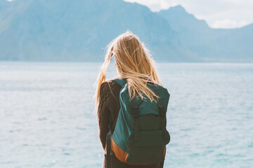 Travel in Norway globetrotter woman with backpack looking at mountains view alone outdoor active...