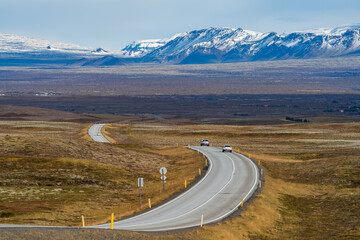 Curved road in Iceland with cars towards the highlands