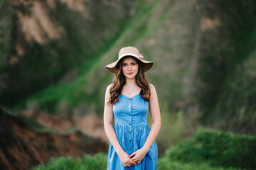 young girl in a straw hat with large brim on mountain slopes