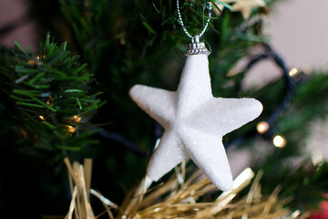 Estrella blanca con purpurina colgada del árbol de Navidad