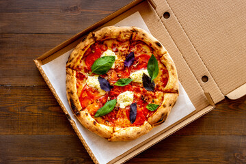 Cut into slices italian pizza with tomatoes cheese and basil