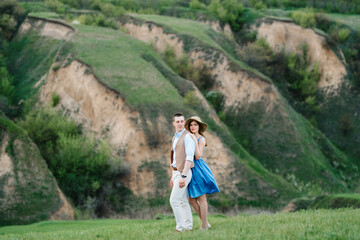 young couple a guy and a girl are walking in the mountain hills