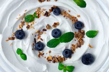 Yogurt with blueberries, granola and mint, top view, food background , close up, macro,