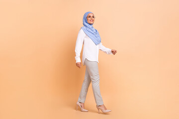 Full length profile photo of young arabic modern lady go wear headscarf shirt eyewear pants stilettos isolated on peach background