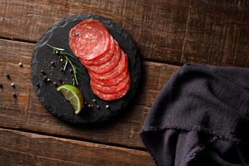 fatias de salame sobre pedra de marmore em fundo de madeira rústica © Pic_It
