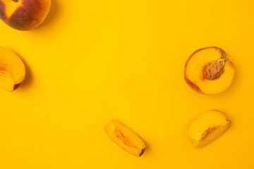 Ripe juicy peaches on yellow background. Flat lay, top view, copy space.