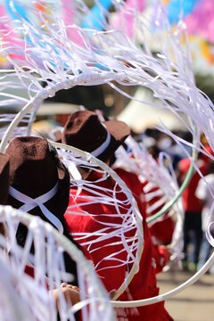 Back view of people in red shirts and brown hats at the traditional festival of the state of Minas Gerais in Brazil