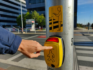 Someone is pressing the pedestrian traffic light button. In the lightening part of the yellow box...