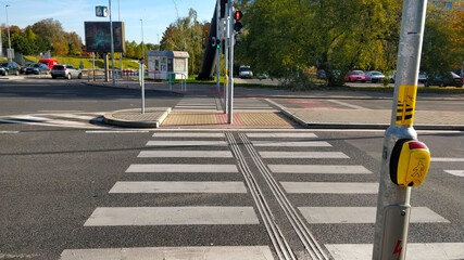 Prague, Czech Republic - October 24, 2021: Empty pedestrian crossing on a busy crossroad with red color being currently displayed on the traffic light. The yellow button says "Push" in Czech.