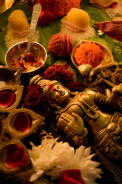 Buddha golden statue surrounded by diya and flowers
