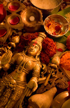 Buddha golden statue surrounded by diya and flowers