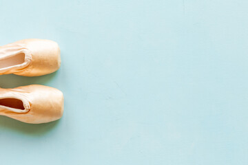 Pair of beige ballet pointe shoes with ribbon, top view