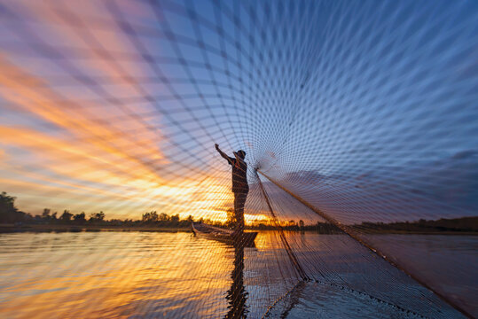 Fisherman throwing net into the ocean