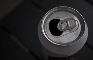 Close-up of an open aluminum can. Top view on empty can on black table background. Copy space