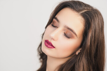 Obraz premium Makeup on young skin. Girl with closed eyes. Face close up. Bright lipstick.