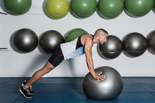 Man doing push-ups using exercise ball at the gym