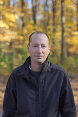 man posing next to a tree
