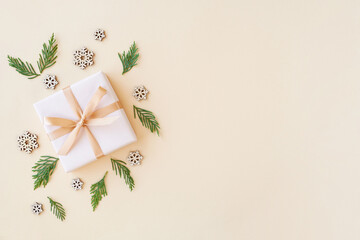 Christmas flat lay background with fir tree,  gift box and wooden snowflakes. Free space , top view