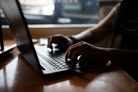 Person sitting near window using laptop