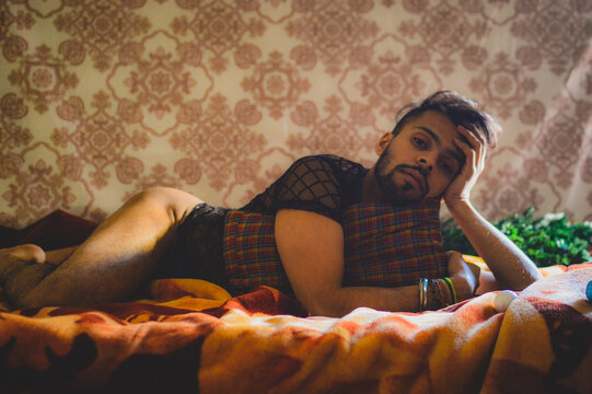 Seductive man lying on bed