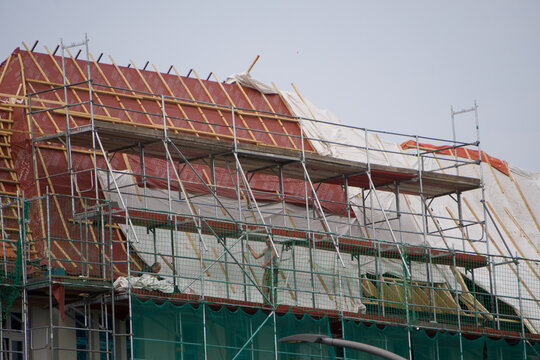 Scaffolding surrounding a building with red bricks