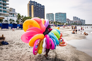Street seller holding inflatable rings at the beach in Cartagena, Bolivar,  Colombia
