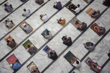 Top view of muslim men praying and social distancing in mosque