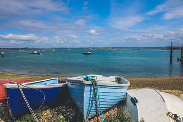 Two blue boats on shore in front of sea