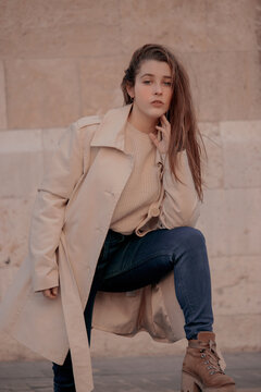 Woman in pink coat and blue denim jeans standing outdoor
