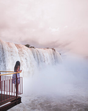Woman standing on balustrade near waterfalls