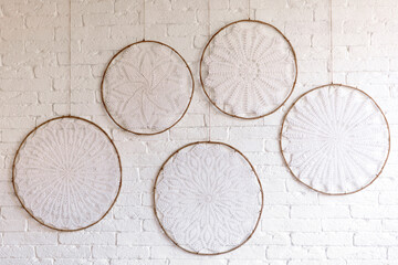 Beautiful home interior with white and beige tones, with dream catchers, dry flowers and a bed